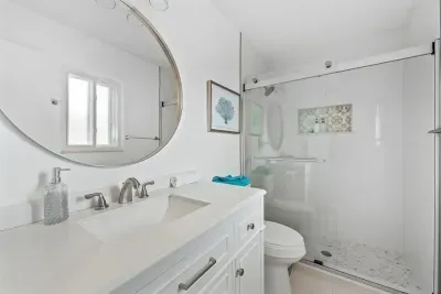 Fresh and bright bathroom with modern finishes and a clean, spa-like feel. Featuring a stylish vanity, updated fixtures, and a spacious walk-in shower with glass doors. Crisp, comfortable, and perfect for getting ready with ease during your stay.