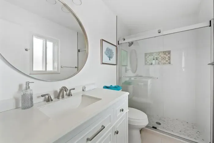 Fresh and bright bathroom with modern finishes and a clean, spa-like feel. Featuring a stylish vanity, updated fixtures, and a spacious walk-in shower with glass doors. Crisp, comfortable, and perfect for getting ready with ease during your stay.
