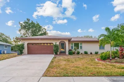 Welcome to your sunny Florida getaway! This charming home features great curb appeal, a spacious driveway, and lush tropical landscaping.