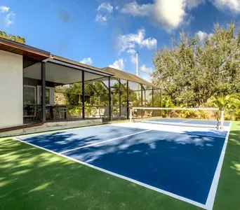 Serve, rally, and relax in your own backyard paradise! This private pickleball court sits beside a spacious screened patio with tropical landscaping and sunny skies—perfect for entertaining, staying active, and enjoying Florida living year-round.