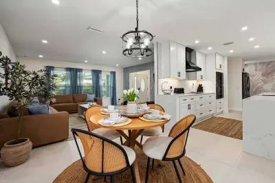 Enjoy meals and meaningful moments in this bright open-concept living space featuring a cozy dining area, designer kitchen, and relaxing lounge.
