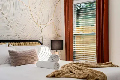 Relax in this beautifully styled bedroom featuring elegant botanical wall art, soft natural light, and cozy modern touches. Thoughtfully designed for comfort and tranquility, it’s the perfect retreat for restful nights and peaceful mornings.