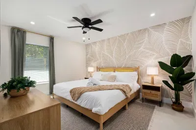 Unwind in this beautifully styled bedroom featuring a plush king bed, elegant tropical-inspired wallpaper, warm lighting, and calming décor. Designed for comfort and relaxation, it’s the perfect private retreat after a day of fun and adventure.