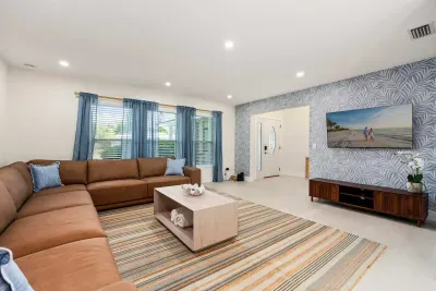 Stretch out and relax in this spacious modern living room featuring oversized sectional seating, stylish décor, and plenty of natural light. Perfect for movie nights, family gatherings, or unwinding after a day by the pool or beach.