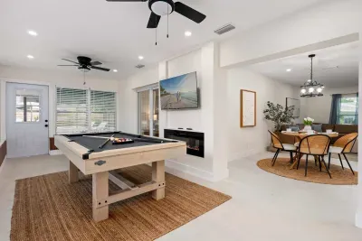 Enjoy endless entertainment in this bright game and gathering space featuring a pool table, large TV, and seamless flow into the dining area. Perfect for friendly competition, movie nights, and creating fun memories with family and friends.