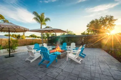 Gather around the glowing fire pit as the sun sets over this tropical backyard retreat. Relax in colorful Adirondack chairs, sip evening drinks, and enjoy warm Florida nights in a stylish outdoor space made for unforgettable memories.