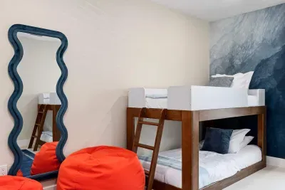This playful bunk room is perfect for kids and teens, featuring cozy built-in bunks, vibrant bean bag seating, and fun modern décor.