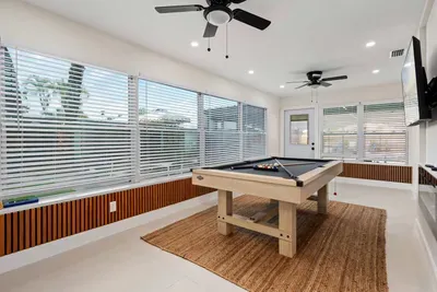 Bring the fun indoors in this sun-filled game room featuring a sleek pool table, oversized windows, and plenty of space to gather. Perfect for friendly matches, relaxing afternoons, and creating unforgettable memories with family and friends.