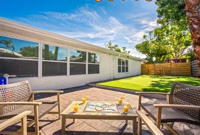 Relax and reconnect in this private outdoor lounge area featuring cozy seating, sunny open skies, and a spacious turf yard perfect for games and gatherings.