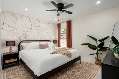 Retreat to this cozy and stylish bedroom featuring a plush king bed, elegant botanical wall art, warm lighting, and modern décor. Designed for comfort and relaxation, it’s the perfect peaceful space to unwind after a day of adventure.
