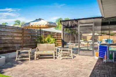 Gather outdoors in this charming private patio space featuring cozy lounge seating, tropical landscaping, and easy access to the screened-in pool area. Perfect for morning coffee, evening conversations, and relaxing under the Florida sunshine.