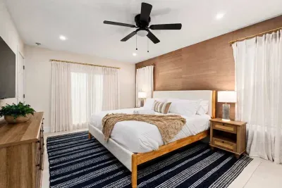 Relax in this serene and beautifully designed bedroom featuring a plush king bed, warm wood accents, soft natural light, and modern coastal touches. The perfect private retreat for restful nights and peaceful vacation mornings.