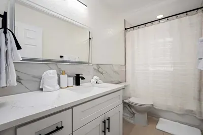 Enjoy a clean and modern bathroom designed with comfort in mind, featuring sleek finishes, a spacious vanity, and fresh spa-like touches. Perfect for refreshing after a beach day or getting ready for a relaxing night out.