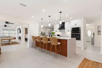 Step into this bright and modern chef’s kitchen featuring sleek finishes, double ovens, and a spacious island with bar seating. Designed for gathering, cooking, and entertaining, this open layout keeps everyone connected throughout your stay.