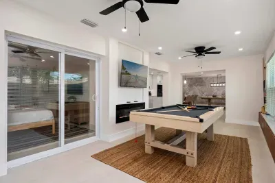 Challenge friends to a game of pool in this bright and stylish entertainment space featuring indoor-outdoor access, modern finishes, and plenty of room to relax. Perfect for game nights, casual hangouts, and unforgettable vacation fun together.