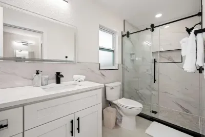 Refresh and recharge in this sleek modern bathroom featuring a spacious glass walk-in shower, elegant finishes, and bright spa-like design. Stocked with essentials and thoughtfully styled for a relaxing, hotel-quality experience during your stay.