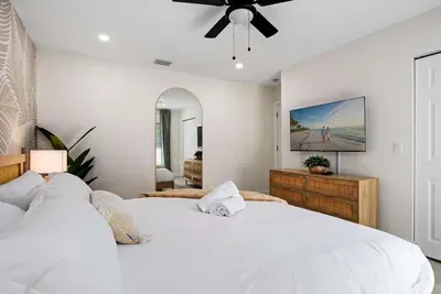 Relax in this spacious and beautifully styled bedroom featuring a plush king bed, calming coastal décor, and modern furnishings. Thoughtful touches, soft lighting, and a peaceful atmosphere create the perfect retreat for restful vacation nights.