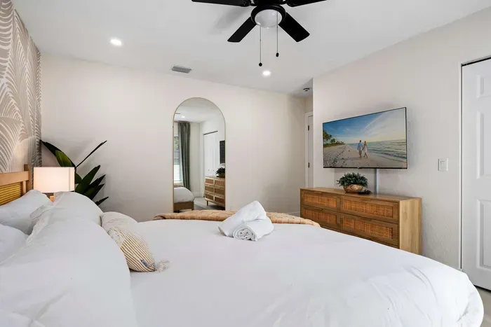 Relax in this spacious and beautifully styled bedroom featuring a plush king bed, calming coastal décor, and modern furnishings. Thoughtful touches, soft lighting, and a peaceful atmosphere create the perfect retreat for restful vacation nights.