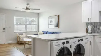 Bright open layout with in-unit washer and dryer tucked under a spacious kitchen island. Modern, airy, and convenient—perfect for extended stays with all the comforts of home.