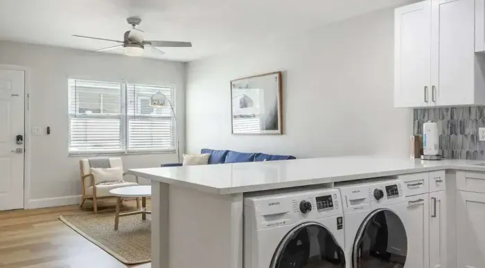 Bright open layout with in-unit washer and dryer tucked under a spacious kitchen island. Modern, airy, and convenient—perfect for extended stays with all the comforts of home.