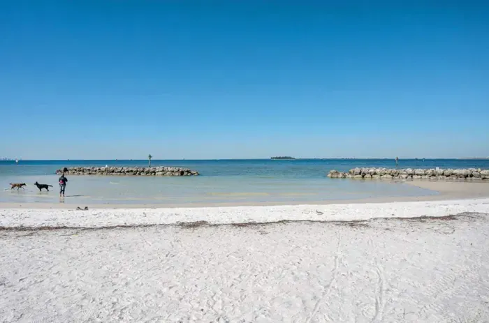 Pristine white-sand beach with calm turquoise waters and endless blue skies. Perfect for a peaceful walk, sunbathing, or swimming—your serene coastal escape just moments away.