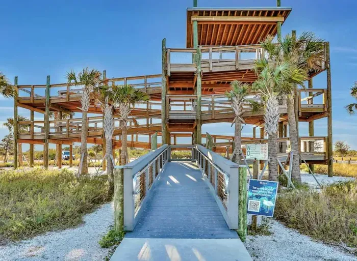 Beautiful multi-level wooden observation deck surrounded by palms and coastal scenery. Enjoy panoramic views, ocean breezes, and stunning sunsets from this peaceful waterfront lookout.