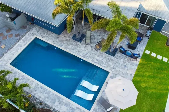 Tropical retreat vibes! 🌴 Relax in this private backyard oasis featuring a sleek pool with in-water loungers, swaying palms, and stylish patio seating. Perfect for sunbathing, sipping cocktails, or enjoying tranquil evenings under the stars.