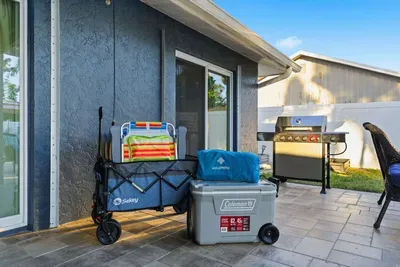 Outdoor entertaining made easy with a BBQ grill, cooler, and beach gear ready to go. Perfect for cookouts or a day of adventure under the Florida sun.