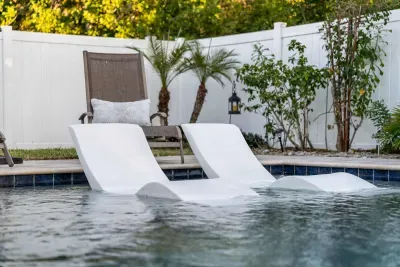 Sink into serenity—enjoy poolside perfection with in-water loungers designed for ultimate relaxation. Surrounded by lush greenery and privacy fencing, this tranquil spot is your own slice of paradise to unwind, sunbathe, or sip something cool.