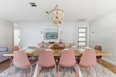 Stylish dining room featuring a modern wooden table, chic blush chairs, and a stunning beaded chandelier. Bright and inviting, it’s the perfect space for shared meals, celebrations, and unforgettable conversations.