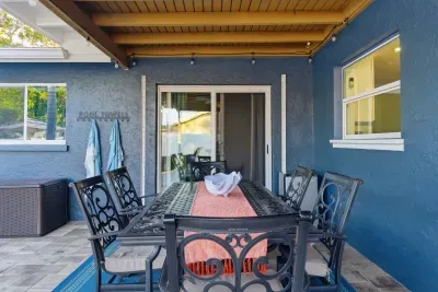 Charming covered patio with elegant dining furniture and pool access, perfect for alfresco meals or evening gatherings. Enjoy shaded comfort and a seamless indoor-outdoor experience.