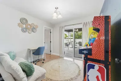 Fun and versatile room featuring a cozy futon, desk space, and mini arcade game. Perfect for work, play, or extra guests—complete with easy patio access for indoor-outdoor enjoyment.