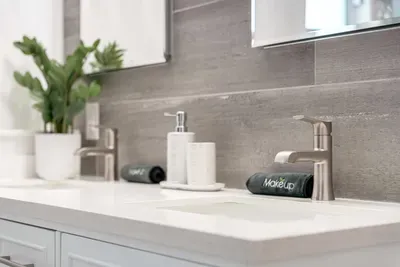 Sleek bathroom vanity with modern fixtures, fresh greenery, and elegant tile detailing. Thoughtfully designed for comfort and style, offering a refreshing start or relaxing end to your day.