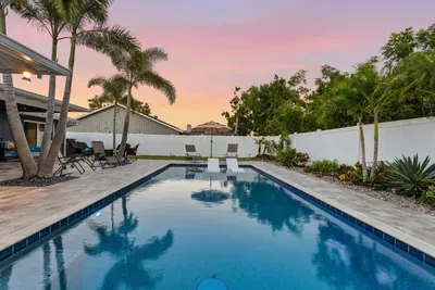 Tranquil poolside paradise framed by palm trees and sunset skies. Perfect for relaxing swims or evening gatherings—your own private retreat with tropical charm.