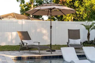 Relax poolside on comfy loungers under a shady umbrella, perfect for soaking up the sun or sipping a cool drink. This serene setup offers the ultimate in outdoor comfort and leisure.