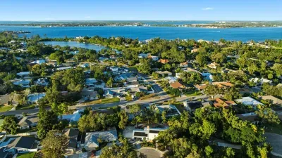 Beautiful aerial view of a coastal neighborhood surrounded by lush greenery and sparkling blue waters—perfectly situated for beach days, sunset strolls, and a relaxing coastal getaway.