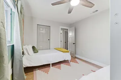 Bright and cheerful bedroom with twin beds, soft pastel accents, and plenty of natural light. A cozy and welcoming space perfect for kids or extra guests.