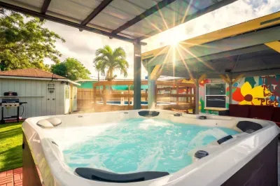 Unwind in your private backyard oasis featuring a hot tub under a covered patio. Playful mural vibes set the scene—perfect for evening soaks, sunny lounging, and unforgettable moments of relaxation.