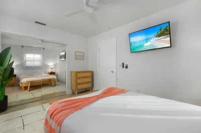 Spacious, light-filled bedroom with plush bedding, wall-mounted TV, and calming coastal vibes. Relax in comfort, enjoy peaceful nights, and unwind in this serene retreat designed for total relaxation.