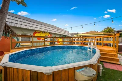 Private above-ground pool with spacious deck, string lights, and colorful mural backdrop. Perfect for cooling off, lounging poolside, or enjoying sunny days and relaxed evenings in your own tropical backyard oasis.