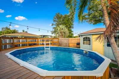 Soak up the sun in this private backyard pool retreat! Surrounded by tropical palms, string lights, and a spacious deck, it’s perfect for refreshing swims, family fun, or relaxing poolside under bright blue skies.