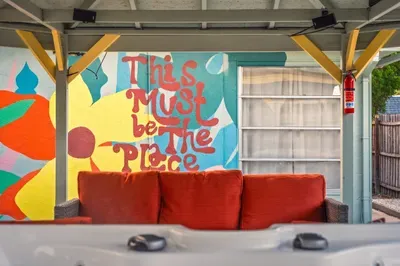 Bold, colorful mural sets the vibe in this fun outdoor lounge, paired with comfy seating and hot tub views. A playful, photo-worthy spot to relax, laugh, and soak up the laid-back beach energy day or night.