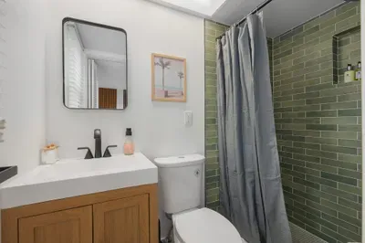 Modern bathroom with sleek vanity, stylish fixtures, and a refreshing tiled shower. Bright and functional, it offers a spa-like feel—perfect for unwinding and getting ready with ease.