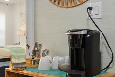 Start your mornings right at this stylish coffee station, fully stocked for easy brewing. Enjoy fresh cups anytime with a convenient setup that adds comfort, charm, and a cozy touch to your stay.