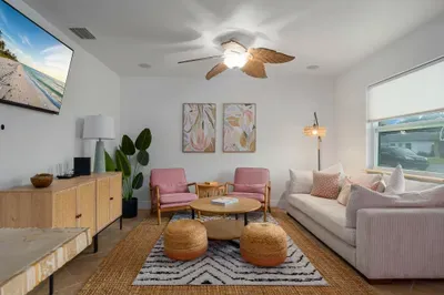 Bright and inviting living room with cozy seating, woven textures, and warm coastal charm. Relax under the ceiling fan, enjoy movie nights, or gather with friends in this stylish space designed for comfort and connection.