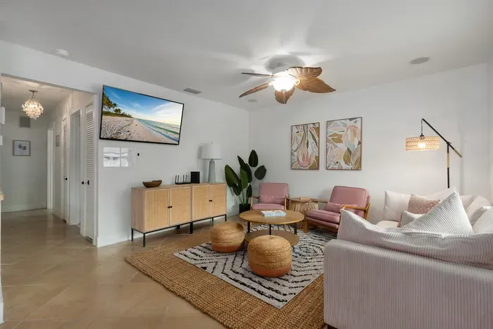 Spacious coastal living room with plush seating, woven accents, and warm natural light. Relax under the ceiling fan, enjoy movie nights, or gather with friends in this stylish, open space made for comfort and connection.