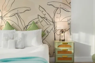Serene bedroom details with plush pillows, soft linens, and a tropical mural accent. Warm lighting and thoughtful décor create a calm, stylish retreat—perfect for relaxing nights and refreshed, peaceful mornings.