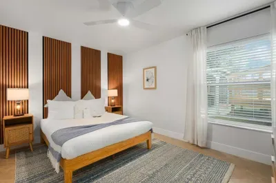 Serene, stylish bedroom with plush bedding, warm wood accents, and soft natural light. Unwind in comfort, enjoy peaceful nights, and wake refreshed in this cozy retreat designed for total relaxation.