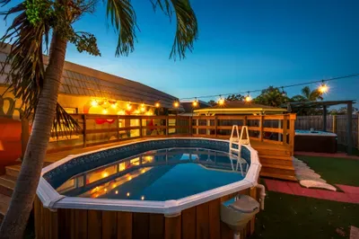 Evenings shine in this private pool paradise with glowing string lights, spacious deck, and tropical palms. Take a sunset swim, relax poolside, or enjoy laid-back nights in this beautifully lit backyard retreat.