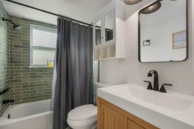 Fresh, modern bathroom with sleek vanity, stylish fixtures, and a tiled tub-shower combo. Clean, bright, and thoughtfully designed, it’s the perfect space to refresh and unwind in comfort.